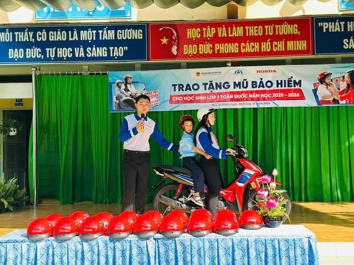 C&oacute; thể l&agrave; h&igrave;nh ảnh về 4 người, xe scooter v&agrave; văn bản cho biết 'MỖI THẤY, C&Ocirc; GI&Aacute;O LA MỘT TẤM GƯƠNG ĐẠO ĐỨC, TỰ HOC V&Agrave; S&Aacute;NG TẠO" HOC TẬP V&Agrave; L&Agrave;M TEO TƯ ƯTƯỞNG, ĐẠO ĐỨC PHONG C&Aacute;CH HỒ CH&Iacute; MINH "PH&Aacute;T H SA 0円 "."" HONDA TRAO TĂNG MŨ BẢO HIỂM CHO HỌC SINH OP TOAN QUỐC N&Atilde;M Hoc 2025 2026 Argo HsCh/Mnh,ngay ngoy 29thởng Jydm2025'